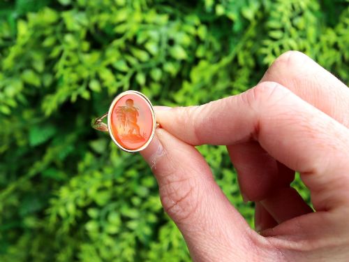 fig 1. An antique 9ct yellow gold ring featuring an oval carved orange agate intaglio depicting a figure with split shoulders.