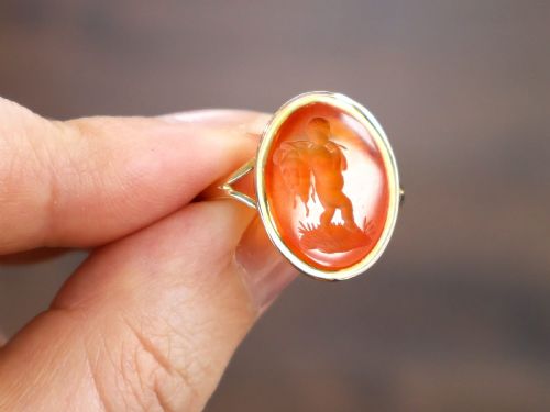 fig 5. An antique 9ct yellow gold ring featuring an oval carved orange agate intaglio depicting a figure with split shoulders.