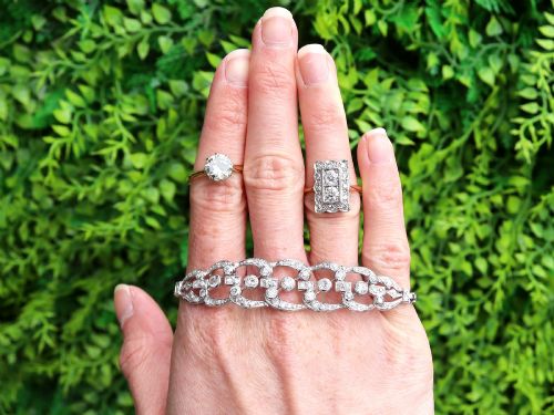 fig 2. An Art Deco 18ct yellow gold dress ring with two central round diamonds within a rectangular millegrain halo setting.