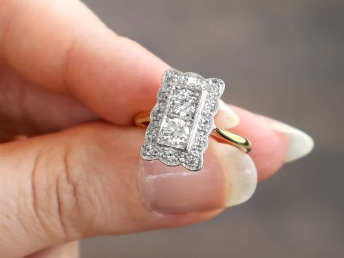 fig 3. An Art Deco 18ct yellow gold dress ring with two central round diamonds within a rectangular millegrain halo setting.