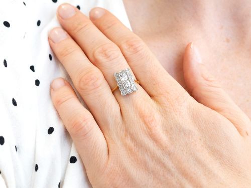 fig 4. An Art Deco 18ct yellow gold dress ring with two central round diamonds within a rectangular millegrain halo setting.