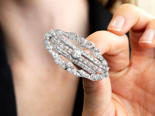 fig 3. An Art Deco platinum brooch styled in an elongated geometric openwork plaque pattern, set throughout with brilliant and square-cut diamonds.