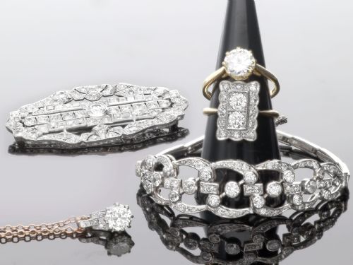fig 3. An antique platinum solitaire pendant featuring a round diamond in a claw setting suspended from a fine gold chain.
