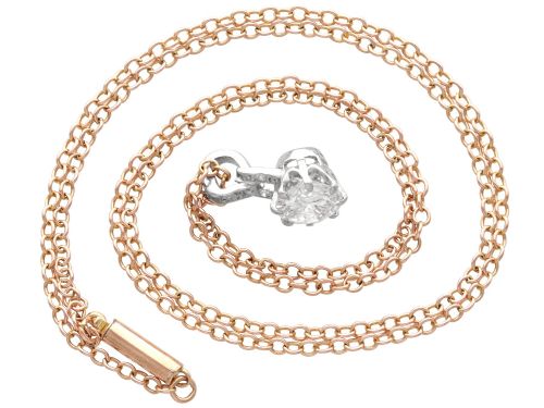 fig 4. An antique platinum solitaire pendant featuring a round diamond in a claw setting suspended from a fine gold chain.