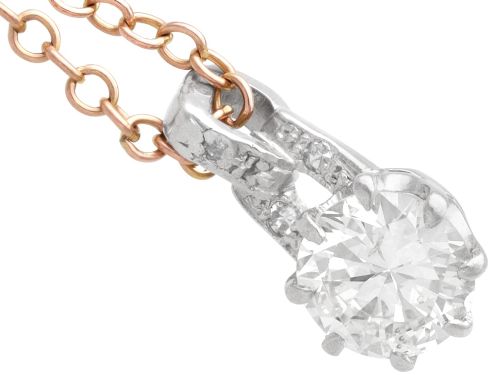 fig 5. An antique platinum solitaire pendant featuring a round diamond in a claw setting suspended from a fine gold chain.