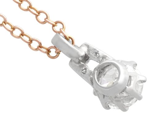 fig 6. An antique platinum solitaire pendant featuring a round diamond in a claw setting suspended from a fine gold chain.