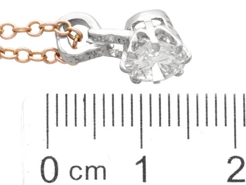 fig 7. An antique platinum solitaire pendant featuring a round diamond in a claw setting suspended from a fine gold chain.