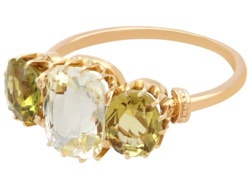 fig 6. A late Victorian 18ct yellow gold trilogy ring featuring a central cushion-cut yellow sapphire flanked by two greenish-yellow chrysoberyl gemstones in claw settings.