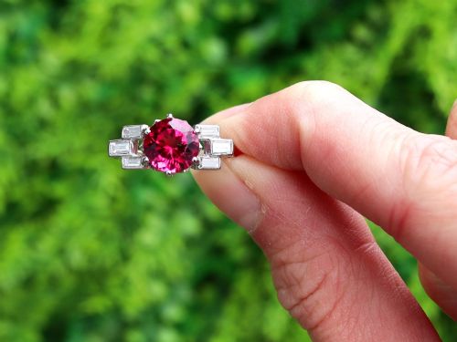 fig 1. An Art Deco platinum ring featuring a round pink tourmaline centre stone set between stepped shoulders of baguette-cut diamonds.