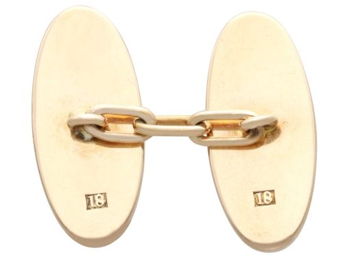 fig 5. A pair of late nineteenth-century double-ended oval cufflinks crafted in 18ct yellow gold, featuring dark patinated shakudo panels with gold and silver botanical relief inlays.
