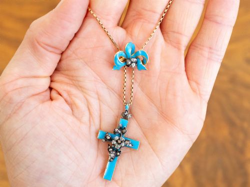 fig 3. A Georgian 15ct yellow gold cross pendant featuring blue enamel, a diamond-set ribbon bow loop, and floral diamond overlays.
