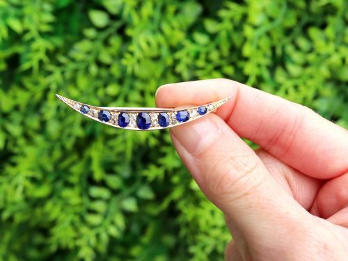 fig 1. An antique late Victorian 9ct yellow gold crescent brooch set with graduated oval blue sapphires and accent diamonds.