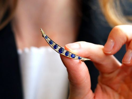 fig 2. An antique late Victorian 9ct yellow gold crescent brooch set with graduated oval blue sapphires and accent diamonds.