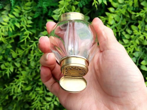 fig 4. A Victorian clear glass scent bottle with fluted sides and engraved sterling silver caps at the top and base.