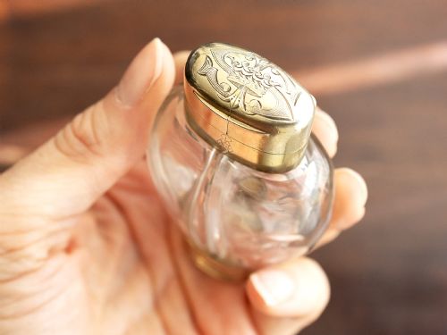 fig 5. A Victorian clear glass scent bottle with fluted sides and engraved sterling silver caps at the top and base.