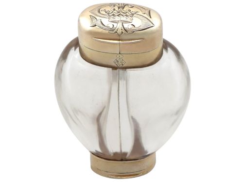 fig 6. A Victorian clear glass scent bottle with fluted sides and engraved sterling silver caps at the top and base.