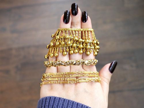 fig 3. An antique Edwardian 15ct gold hinged bangle featuring a twisted ribbon design intertwined around a row of polished gold beads, fitted with a safety chain.