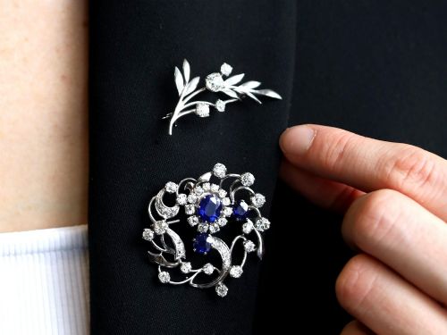fig 2. An 18ct white gold brooch crafted in the shape of a flowering spray, featuring leaf motifs and claw-set diamonds.