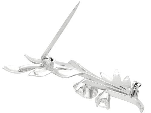 fig 6. An 18ct white gold brooch crafted in the shape of a flowering spray, featuring leaf motifs and claw-set diamonds.