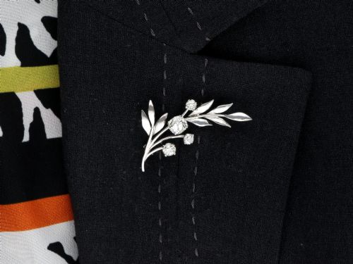 fig 8. An 18ct white gold brooch crafted in the shape of a flowering spray, featuring leaf motifs and claw-set diamonds.