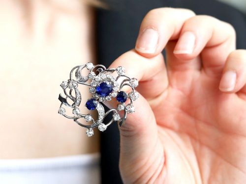 fig 2. An Edwardian 18ct white gold brooch set with three oval blue sapphires surrounded by openwork diamond-set scrollwork.