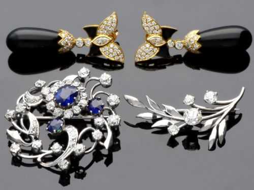 fig 3. An Edwardian 18ct white gold brooch set with three oval blue sapphires surrounded by openwork diamond-set scrollwork.