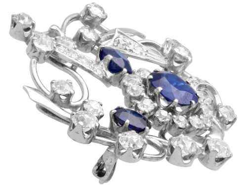 fig 4. An Edwardian 18ct white gold brooch set with three oval blue sapphires surrounded by openwork diamond-set scrollwork.