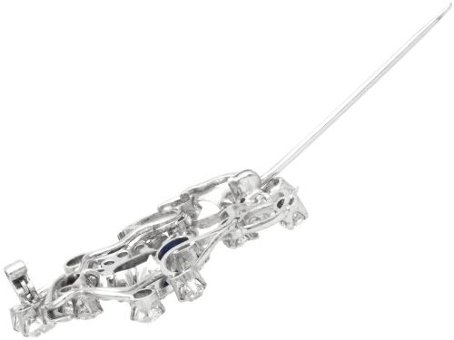fig 7. An Edwardian 18ct white gold brooch set with three oval blue sapphires surrounded by openwork diamond-set scrollwork.