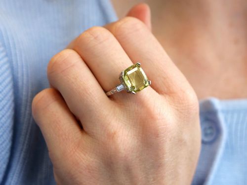 fig 2. An Art Deco platinum ring featuring a large cushion cut yellow chrysoberyl central gemstone flanked by step cut diamonds on the shoulders.