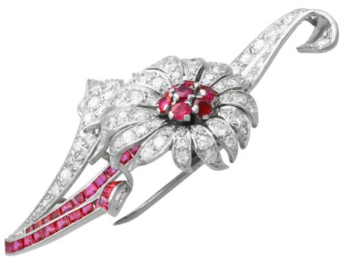 fig 7. A platinum flower brooch featuring diamond-set petals, a cluster of rubies at the centre, and a stem lined with channel-set red rubies.