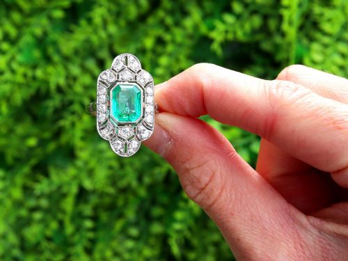 fig 1. An Art Deco platinum dress ring featuring a central rectangular emerald surrounded by an elongated geometric pierced frame set with diamonds.