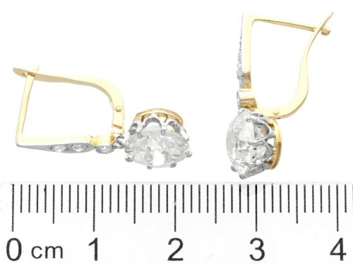 fig 6. A pair of antique diamond drop earrings featuring round diamonds suspended from decorative articulated mounts.