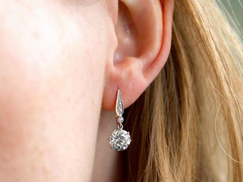 fig 8. A pair of antique diamond drop earrings featuring round diamonds suspended from decorative articulated mounts.