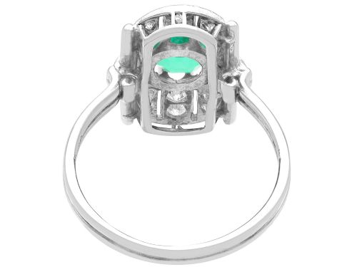 fig 4. An Art Deco 14ct white gold ring featuring a central round green emerald framed by geometric shoulders set with small brilliant diamonds.