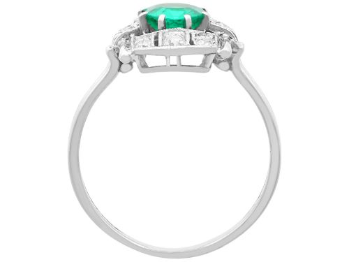fig 5. An Art Deco 14ct white gold ring featuring a central round green emerald framed by geometric shoulders set with small brilliant diamonds.