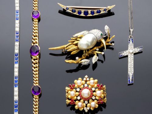 fig 4. An 18ct yellow gold floral cluster brooch set with a central pearl surrounded by small rubies, outer cultured pearls, round diamonds, and red rubies.