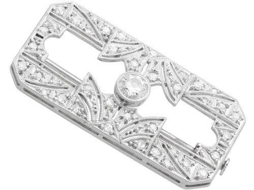 fig 7. A rectangular Art Deco 18ct white gold brooch featuring openwork geometric filigree, millegrain edging, and a central round-cut diamond.