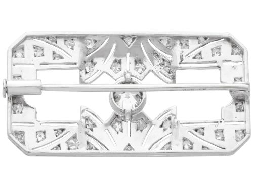 fig 8. A rectangular Art Deco 18ct white gold brooch featuring openwork geometric filigree, millegrain edging, and a central round-cut diamond.