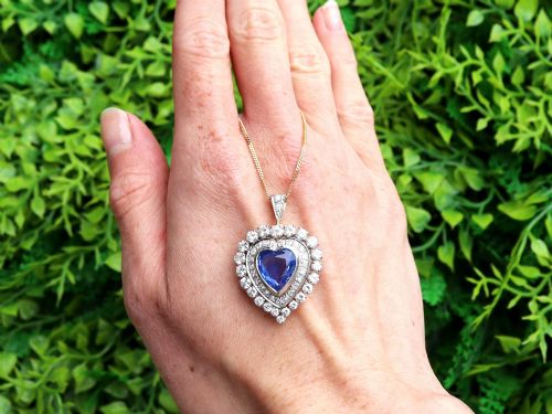 fig 1. A heart-shaped 14ct yellow gold pendant featuring a central heart-cut Ceylon sapphire surrounded by a double halo of brilliant-cut diamonds.