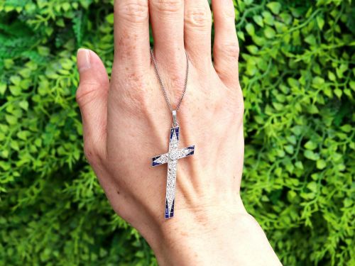 fig 1. An antique Edwardian cross pendant set with diamonds and geometric blue sapphires suspended from a chain.