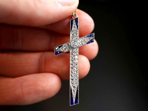 fig 2. An antique Edwardian cross pendant set with diamonds and geometric blue sapphires suspended from a chain.