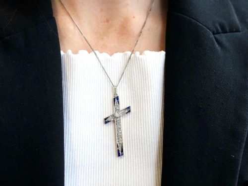 fig 3. An antique Edwardian cross pendant set with diamonds and geometric blue sapphires suspended from a chain.