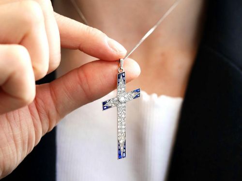 fig 4. An antique Edwardian cross pendant set with diamonds and geometric blue sapphires suspended from a chain.