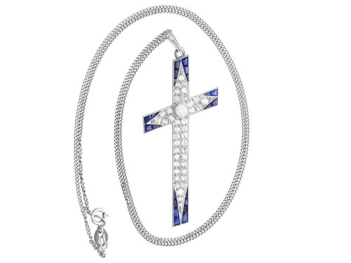 fig 5. An antique Edwardian cross pendant set with diamonds and geometric blue sapphires suspended from a chain.