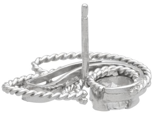 fig 5. A pair of Art Deco platinum earrings featuring round diamonds set within a textured rope-twist swirl design.