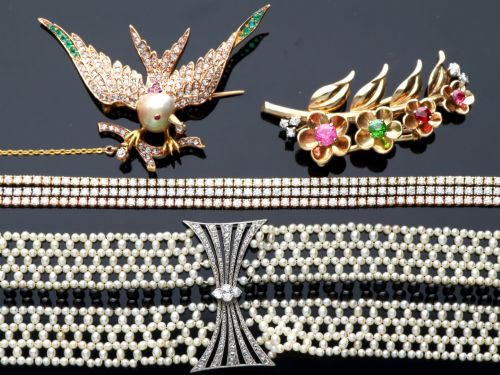 fig 6. An Art Deco multi-strand pearl and black onyx cuff bracelet featuring a central geometric bow-shaped platinum mount set with diamonds.