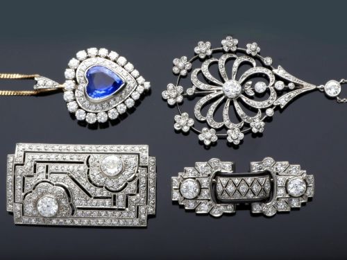 fig 2. A rectangular Art Deco platinum brooch featuring geometric openwork encrusted with round diamonds and two central bezel-set accent diamonds.
