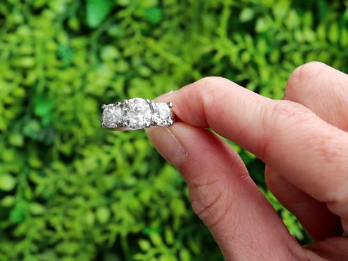 fig 1. An antique platinum trilogy ring set with three cushion cut diamonds and decorated with hand-engraved shoulders.