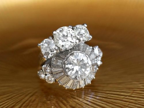 fig 5. An antique platinum trilogy ring set with three cushion cut diamonds and decorated with hand-engraved shoulders.