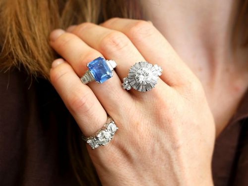 fig 3. An Art Deco platinum ballerina ring featuring a prominent round central diamond surrounded by a radiating halo of tapered baguette cut diamonds.